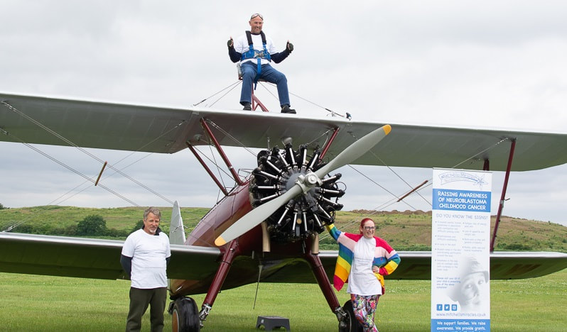Wing Walk fundraising event_Mitchell Miracles supporters smiling to camera standing next to a wing walk plane_Mitchells Miracles_UK Neuroblastoma childrens cancer charity